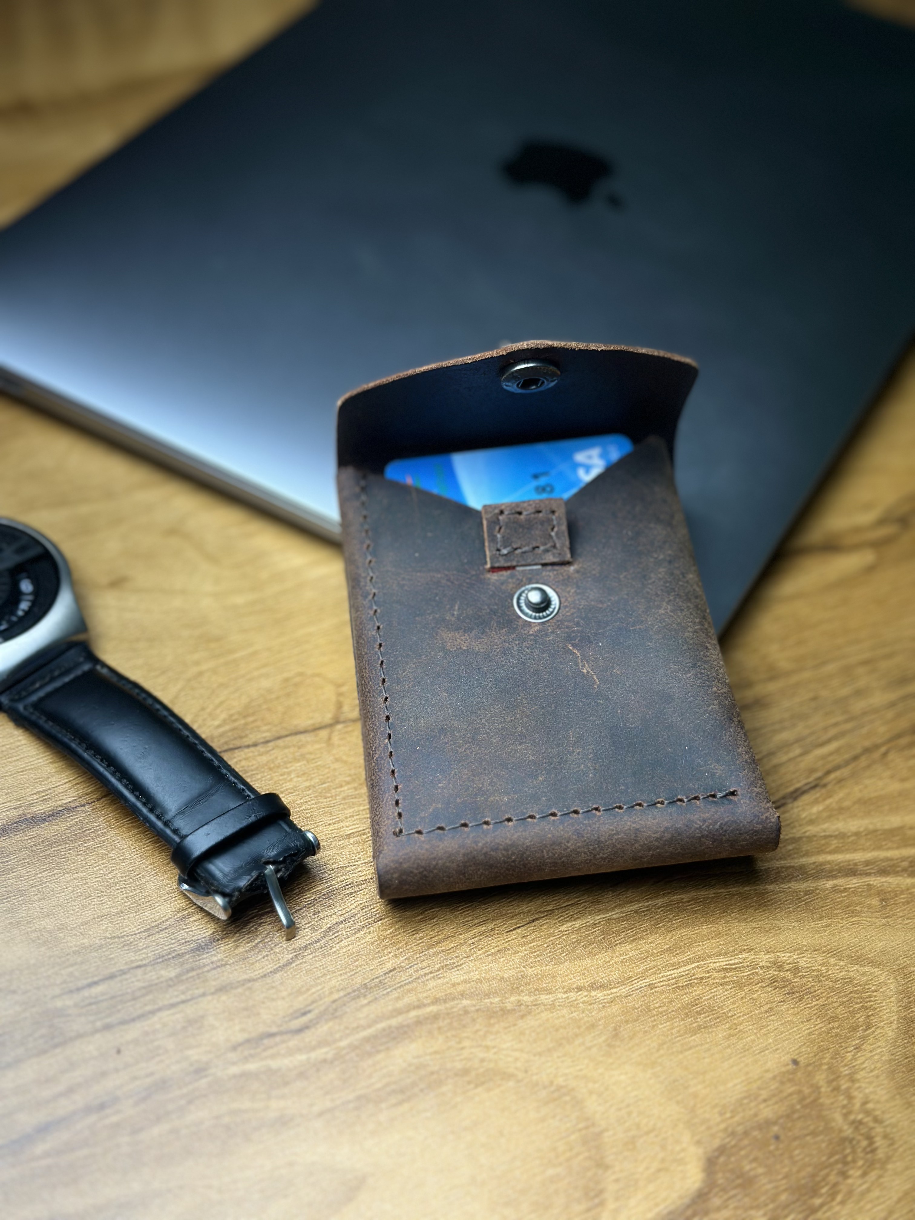 Wallet on desk with watch and MacBook