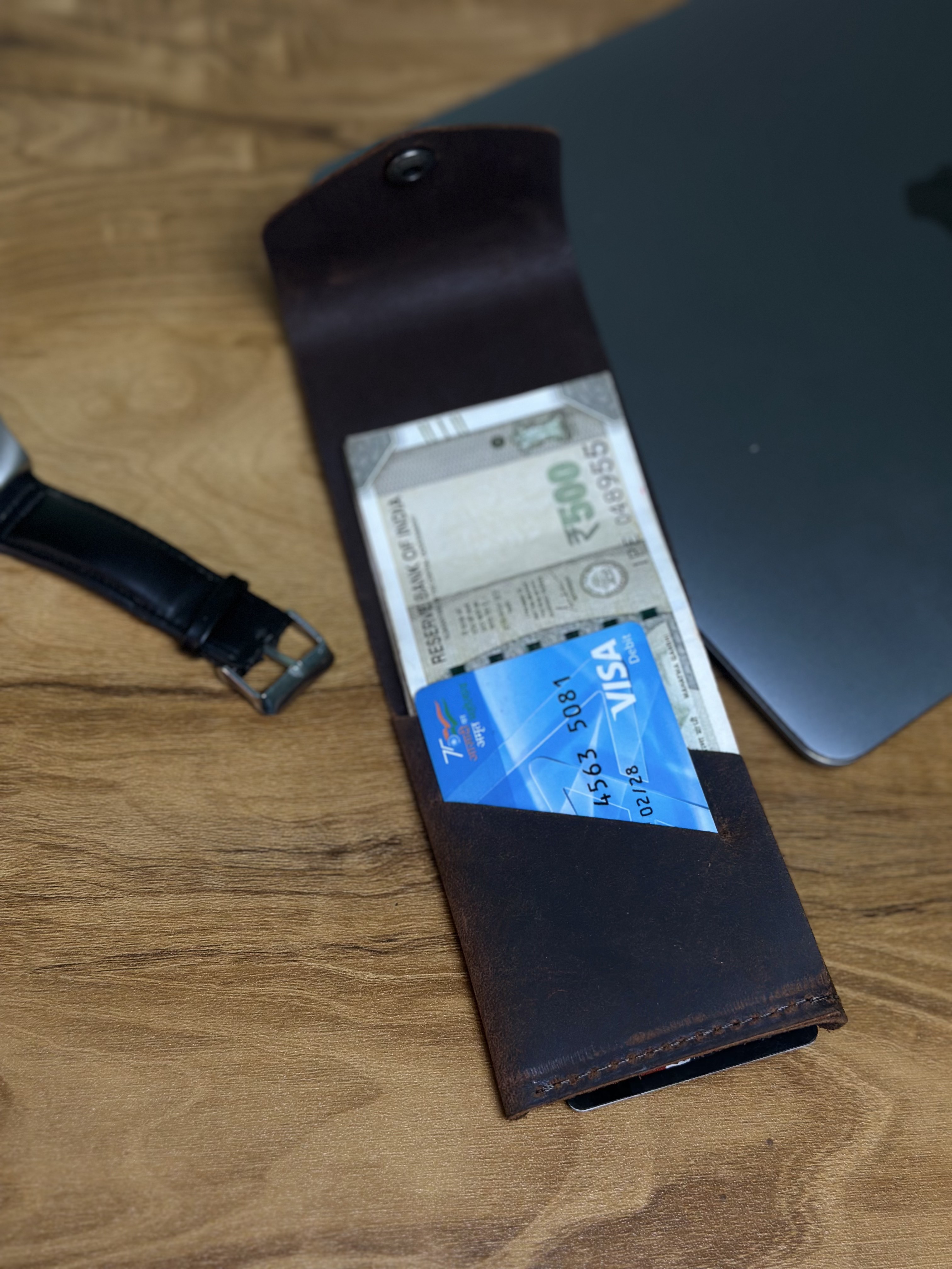 Wallet open — holding cash and card